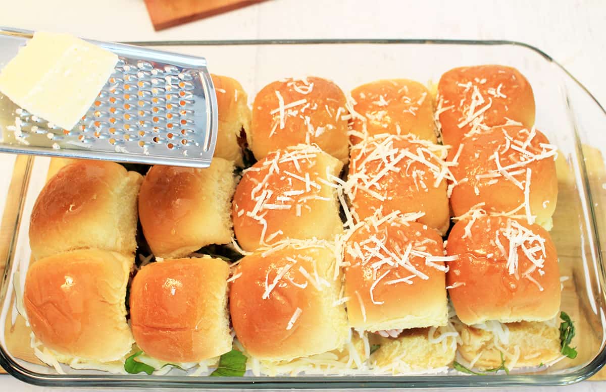Meatballs covered with top of roll and sprinkled with grated Parmesan cheese.