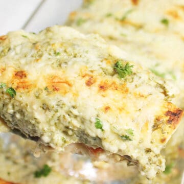 Closeup of a cheesy baked pork enchilada on spatula.