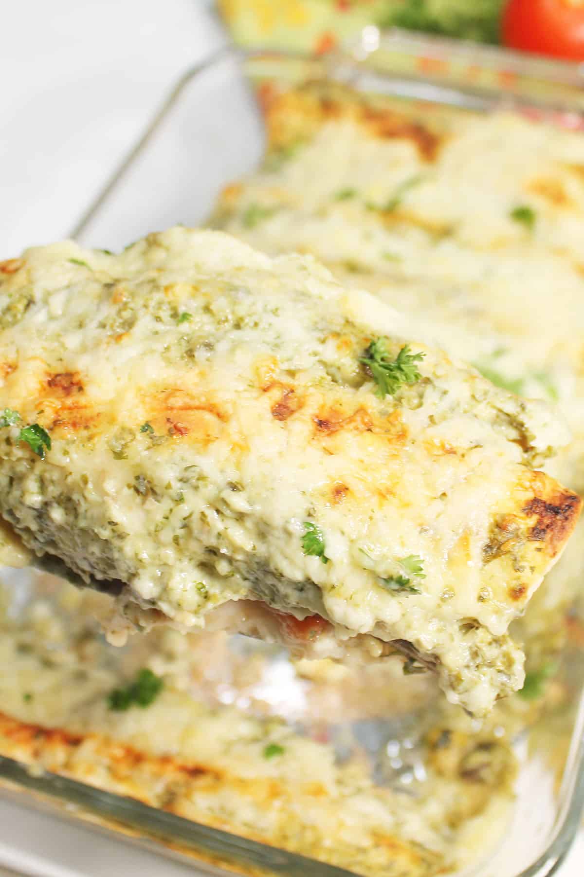 Lifting enchilada out of baking dish.