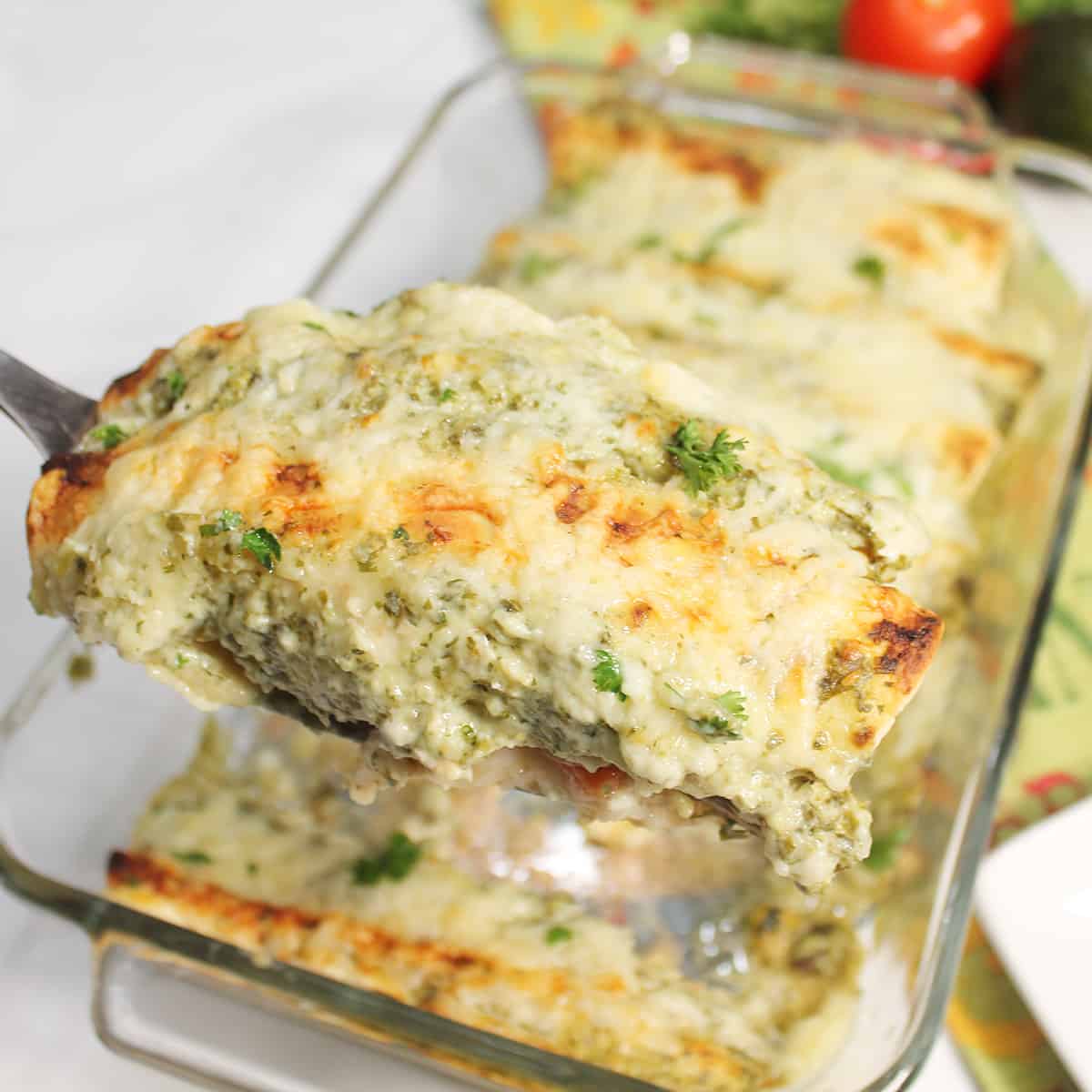 Lifting a pork enchilada out of baking dish.
