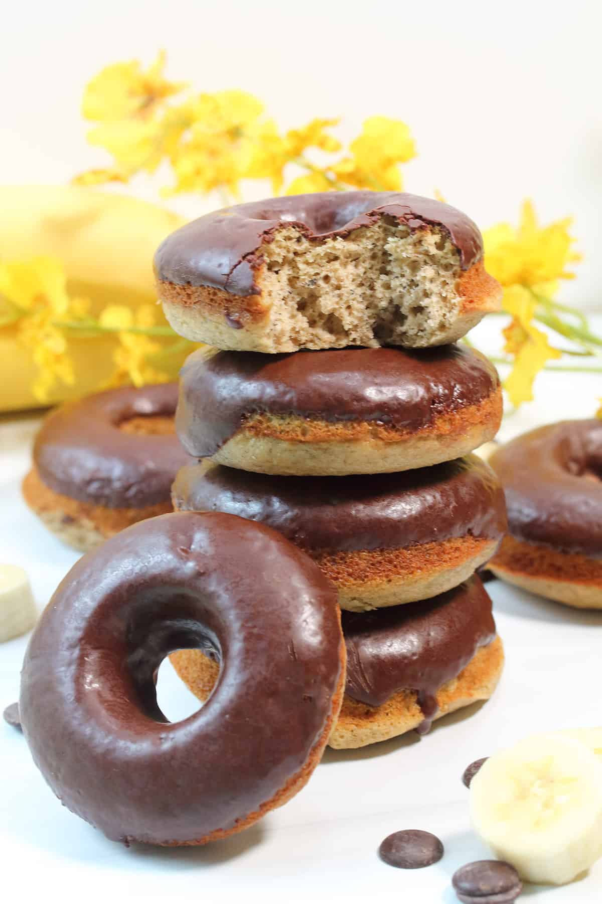 Stacked donuts with bite taken out of top one.