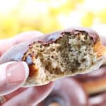 Closeup holding donut with bite taken out of it.