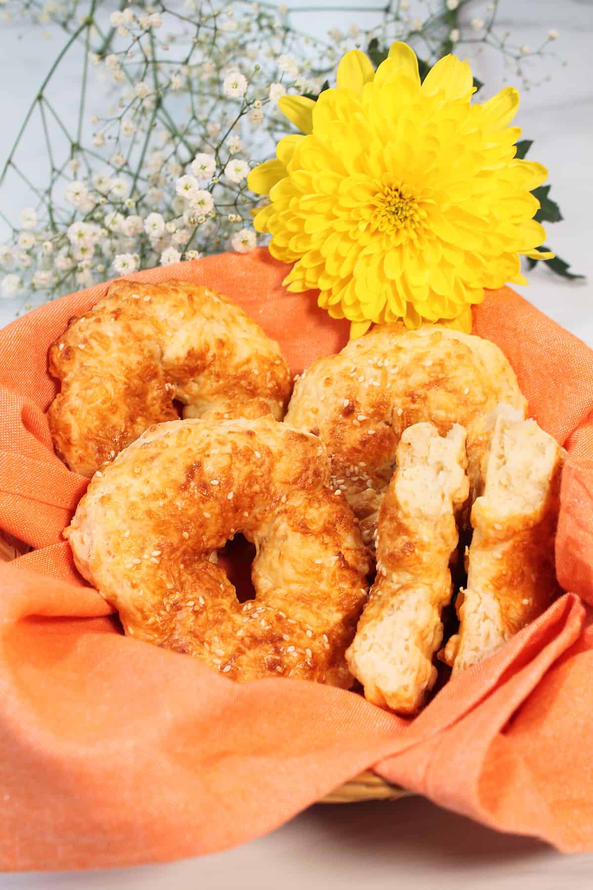 Basket of air fryer bagels with one broken in half.