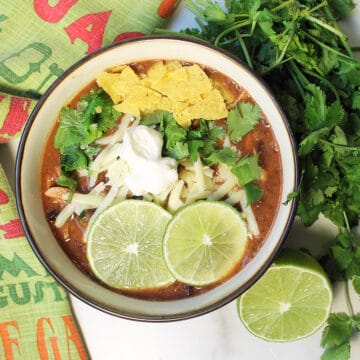 Overhead garnished spicy black bean soup.