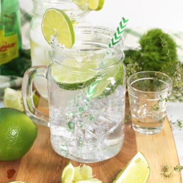 Cocktail with straw and garnished with lime.