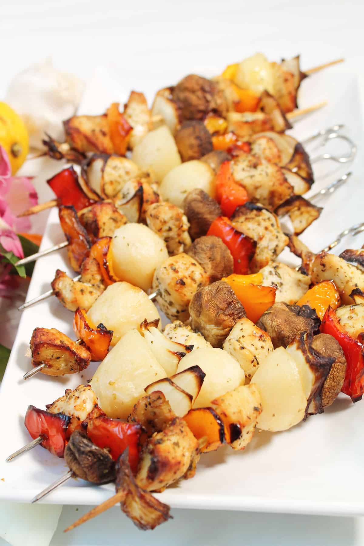 Skewers of air fryer chicken kabobs on platter.