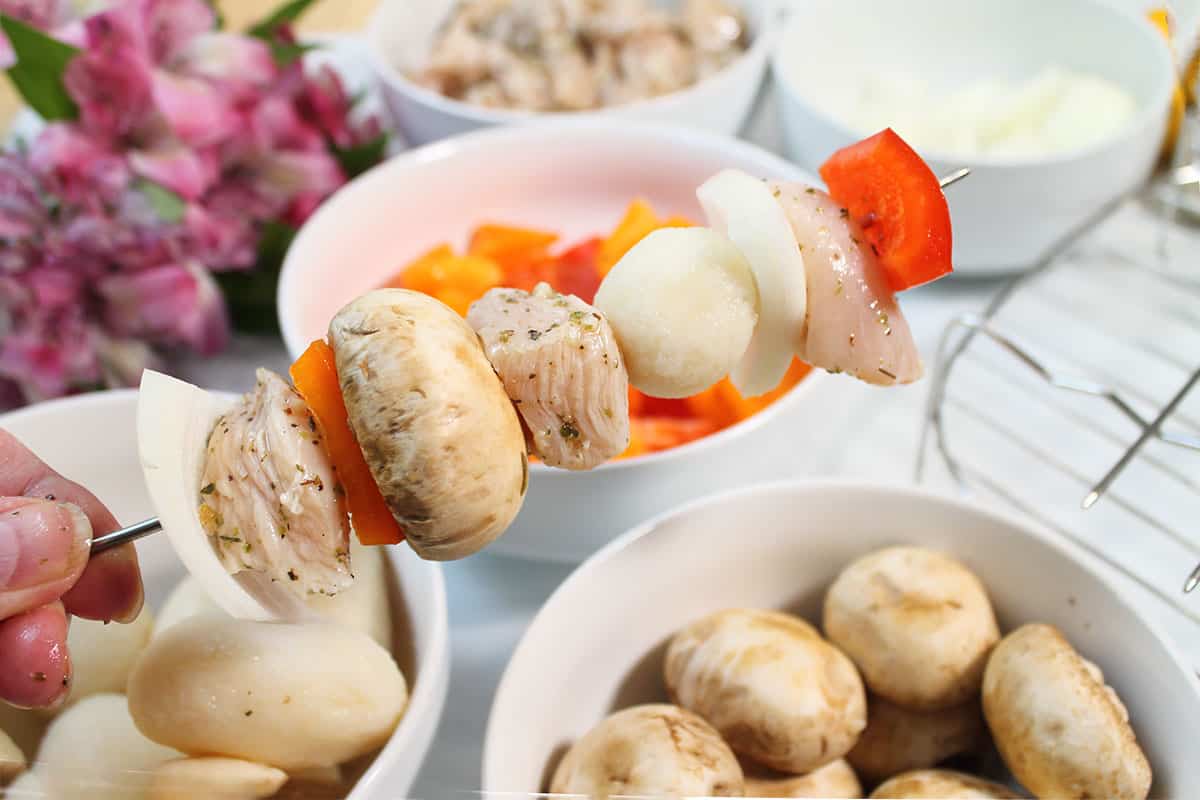 Chicken and vegetables threaded on skewer.