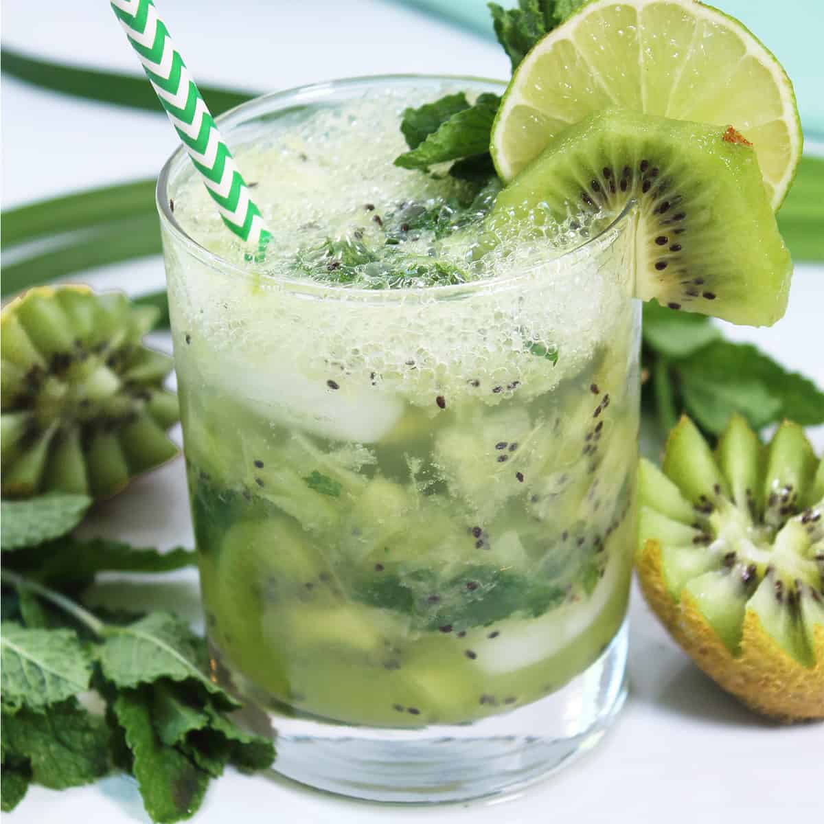 Garnished kiwi mojito with lime slice, kiwi and mint leaf.