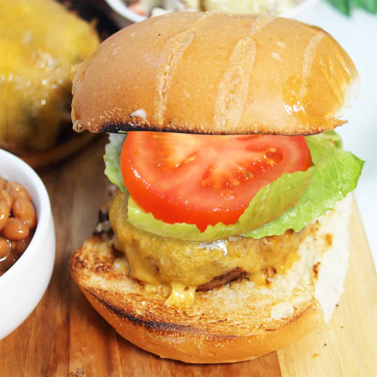 Dressed chorizo cheeseburger on a bun.