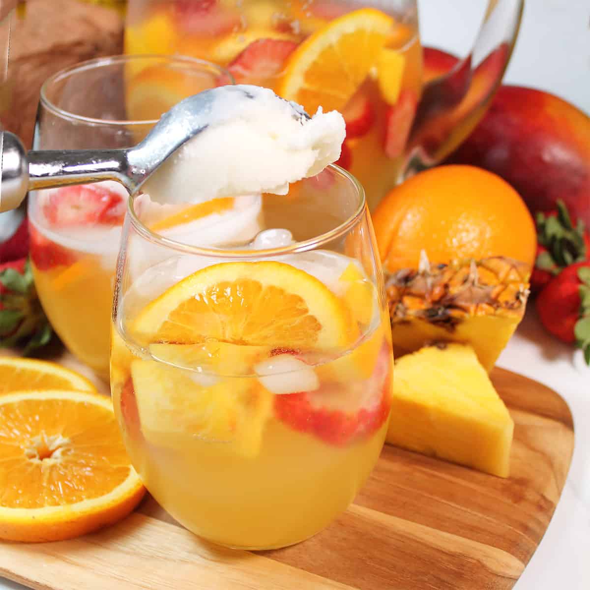 Scooping lemon sorbet into sangria.