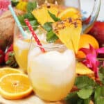 Two glasses Pineapple White wine Sangria among fruit and flowers.