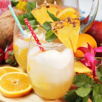 Two glasses Pineapple White wine Sangria among fruit and flowers.