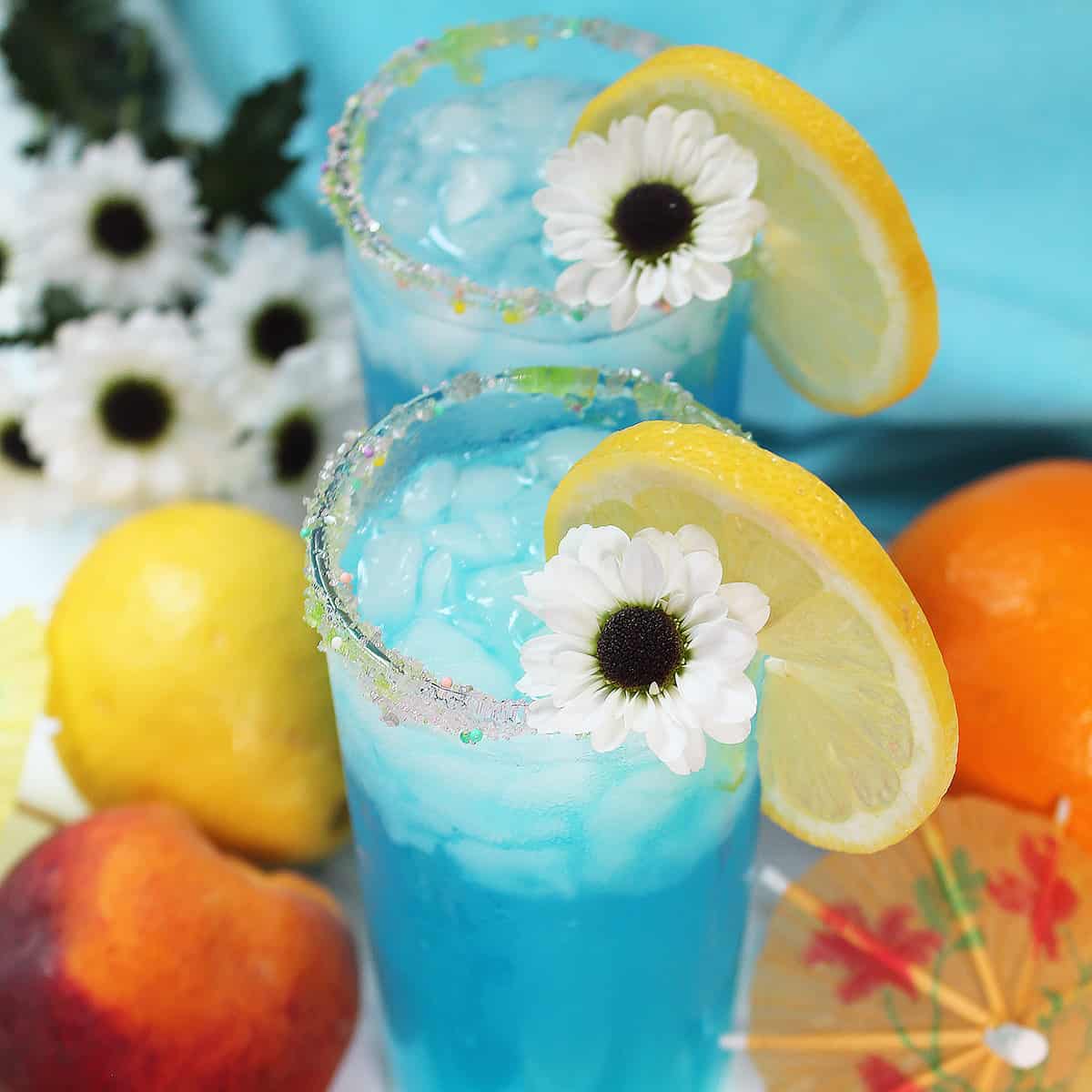 Two Mermaid Water Cocktails with daisies.
