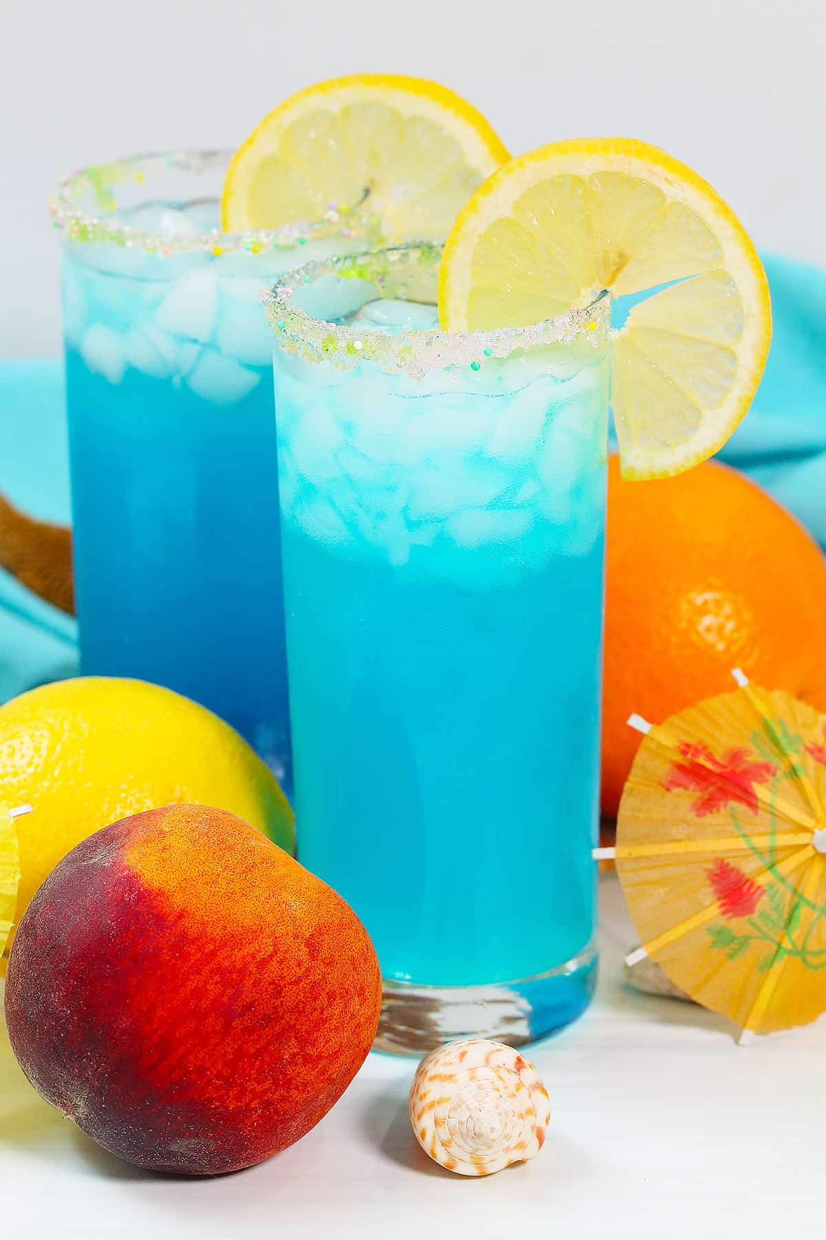 Two Mermaid Water Drinks with fruit around them.