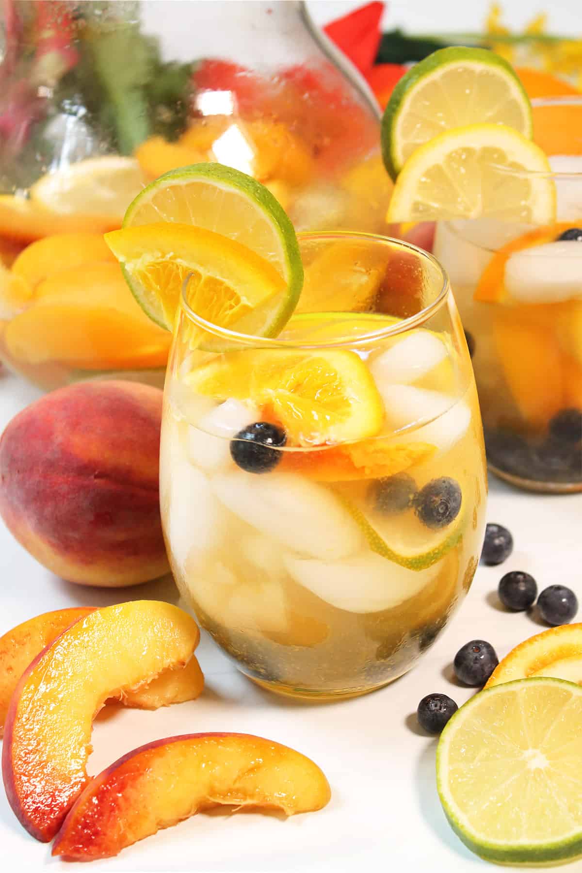 Closeup of garnished glass with peach sangria.