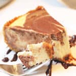Plated marble cheesecake with bite on fork.