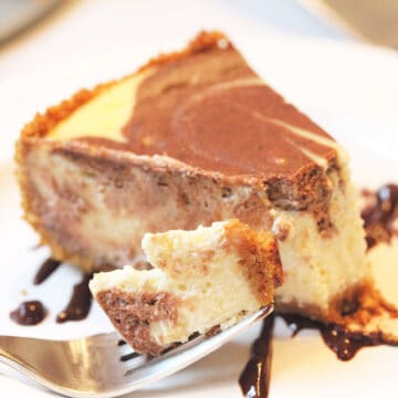 Plated marble cheesecake with bite on fork.