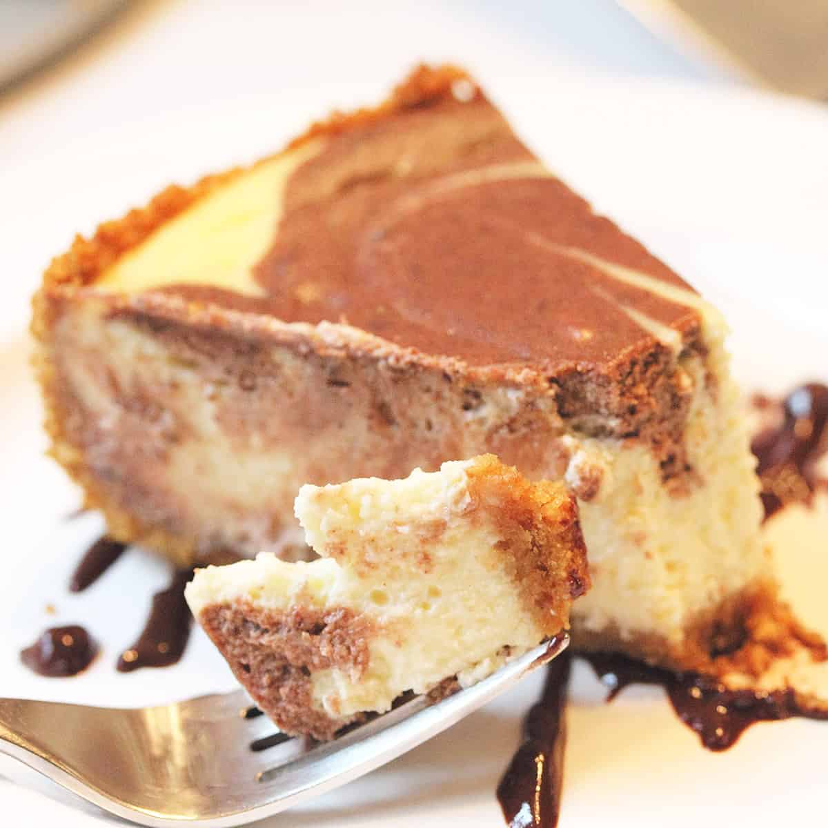 Plated marble cheesecake with bite on fork.