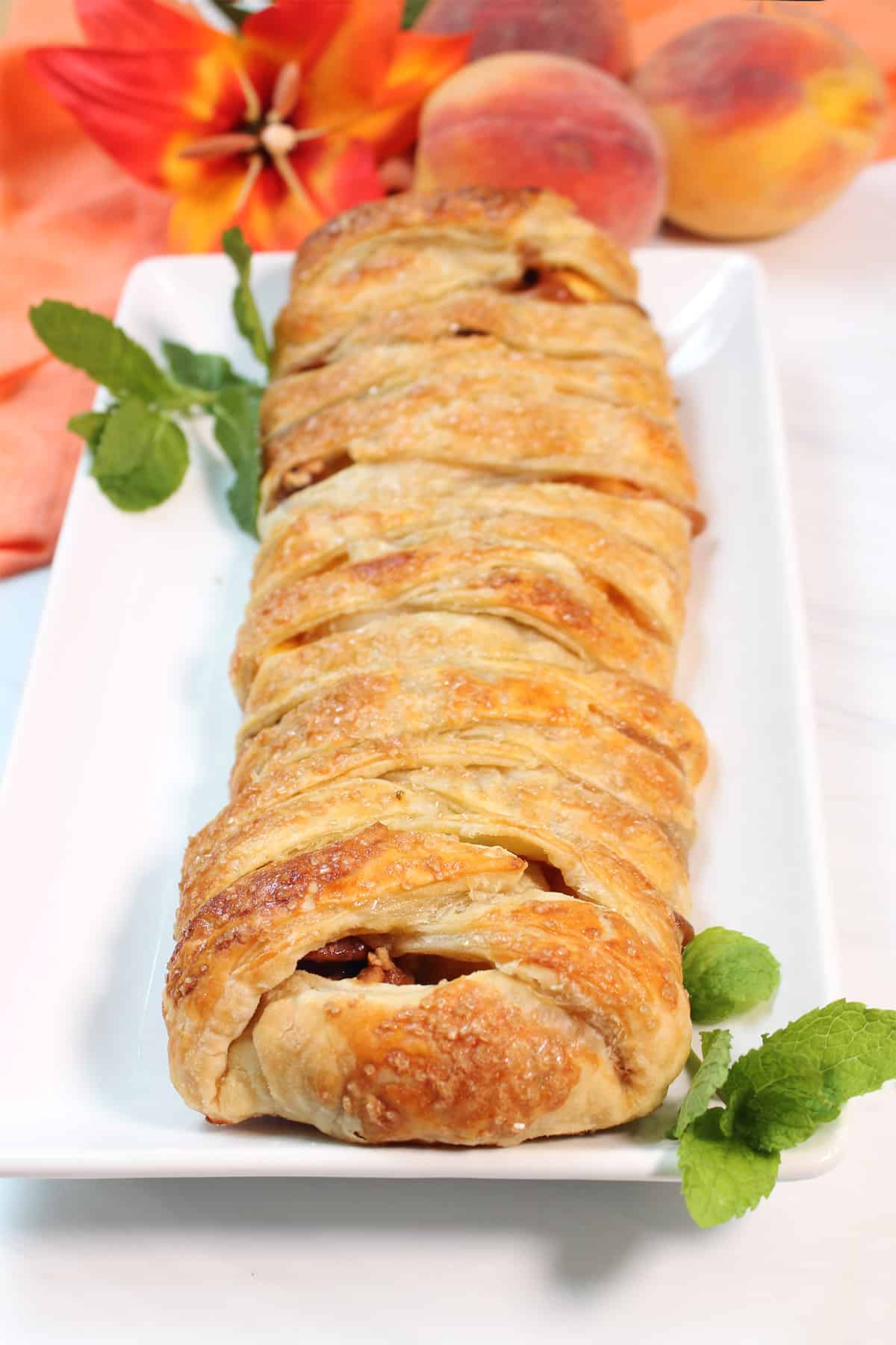Baked braided strudel on white platter.