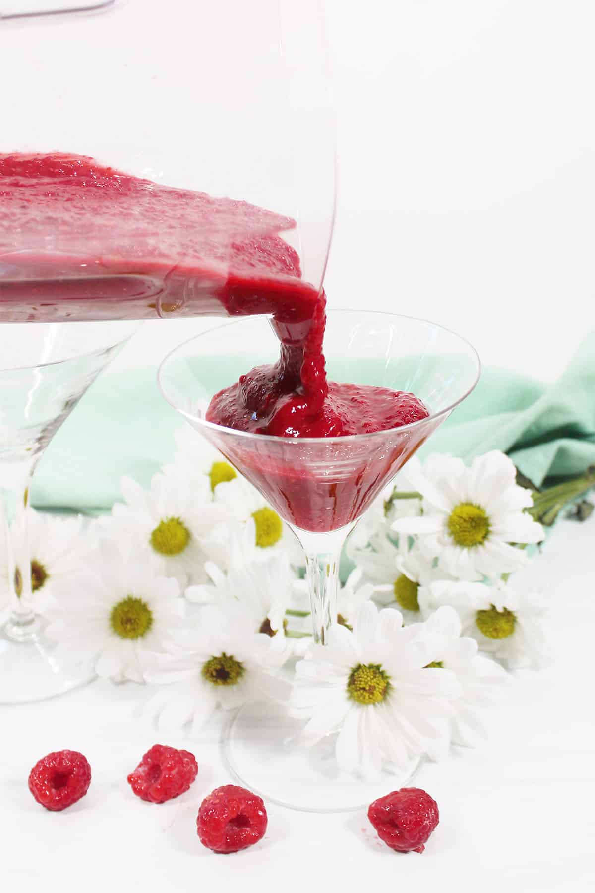 Pouring drink into martini glass.