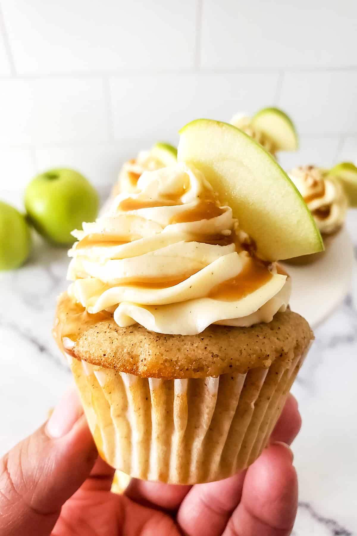 Holding cupcake with caramel buttercream frosting.