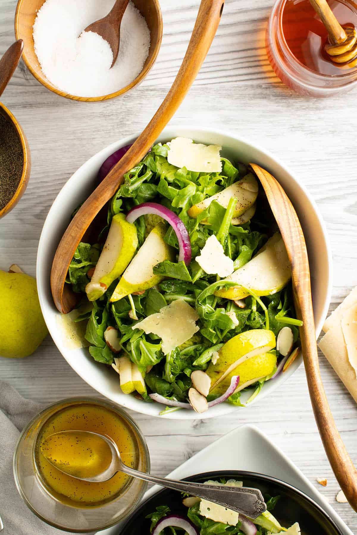 Overhead of arugula pear salad with serveware.