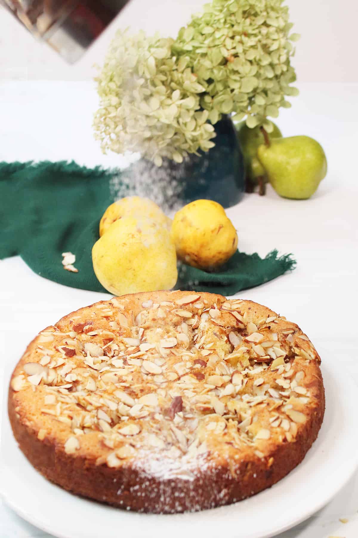 Shaking powdered sugar over cooled cake.