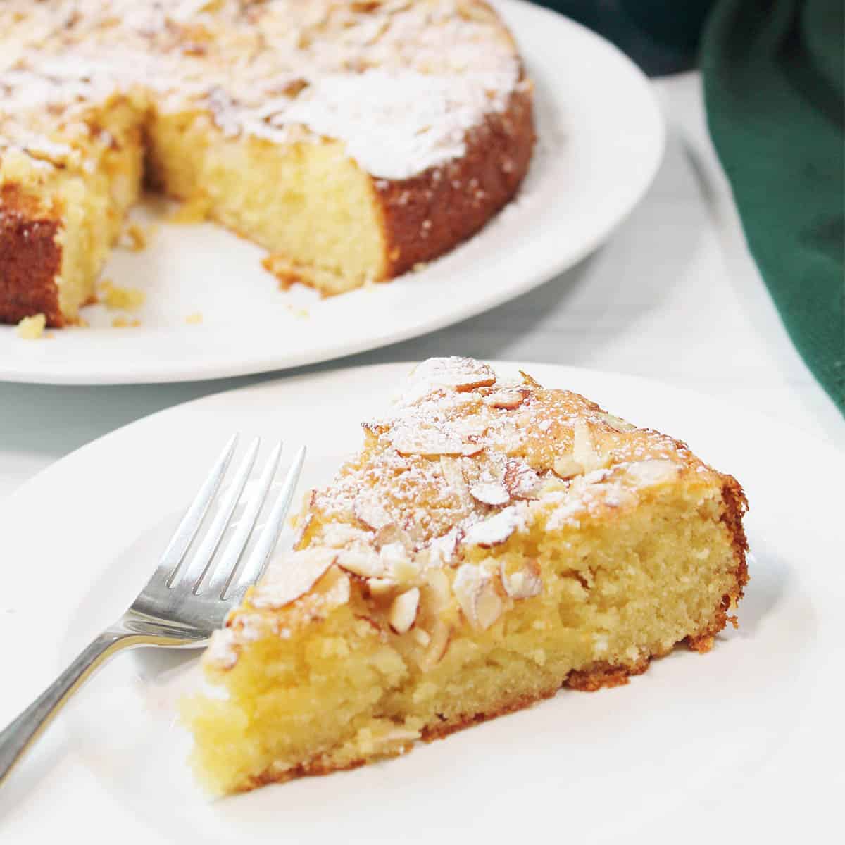Slice of cake in front of pear cake.