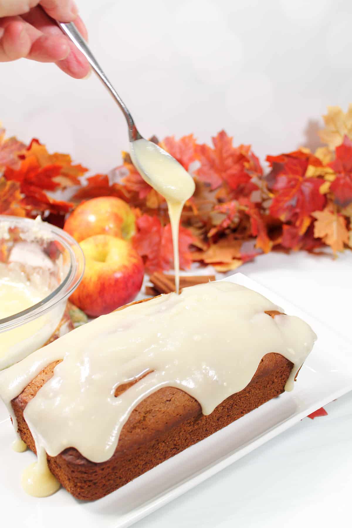 Drizzling cream cheese glaze over cake.