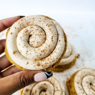Holding finished cookie with cheesecake frosting.