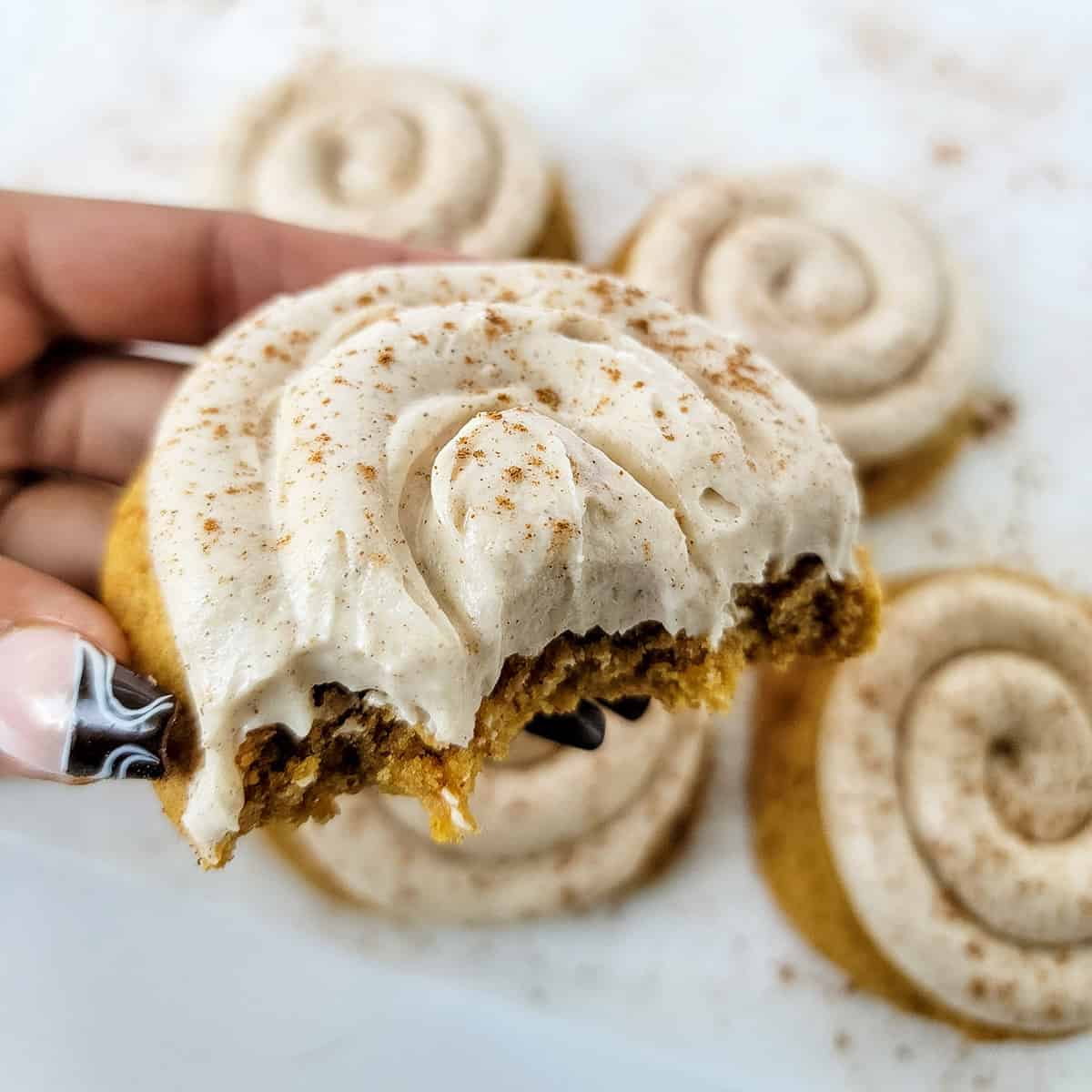 Holding cookie with bite out of it.