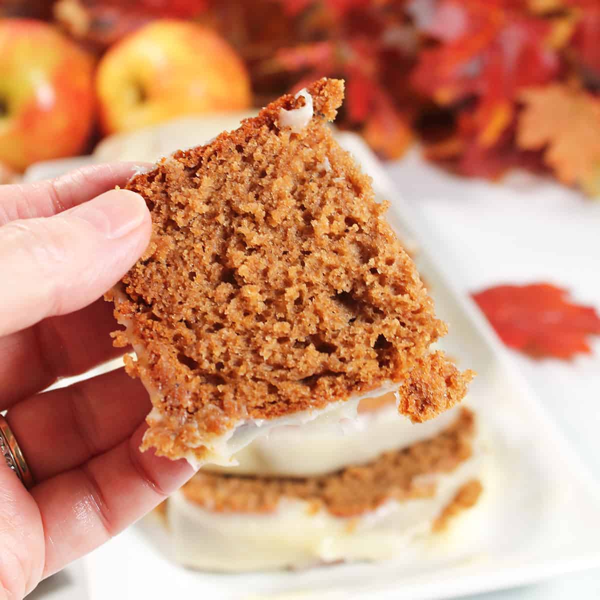 Holding half slice of apple cake.