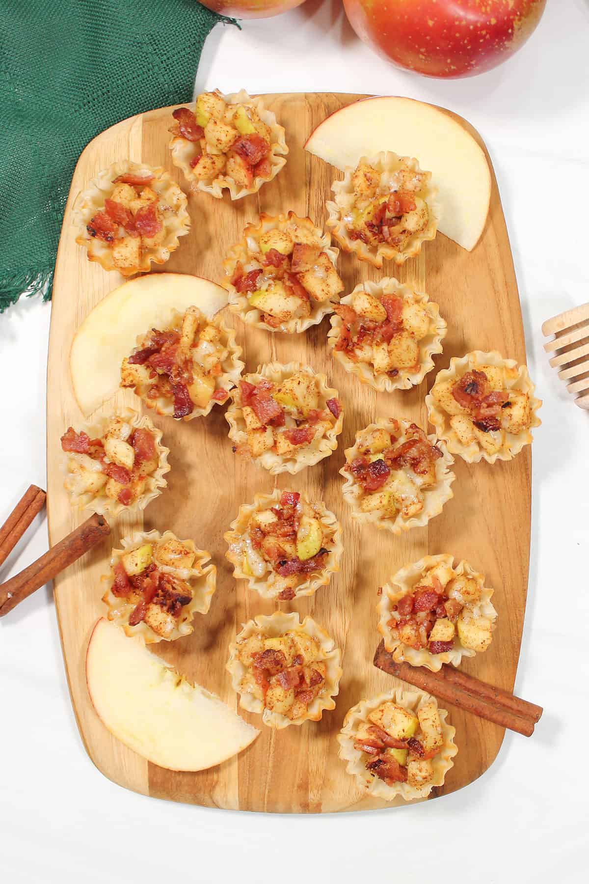 Overhead of apple bacon cheddar bites on wooden board.