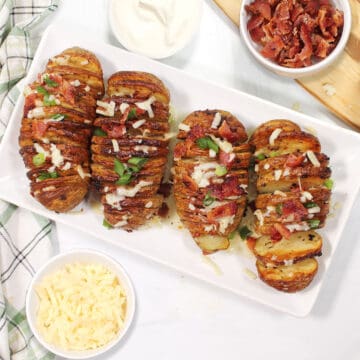 Overhead of four air fryer hasselback potatoes on platter.