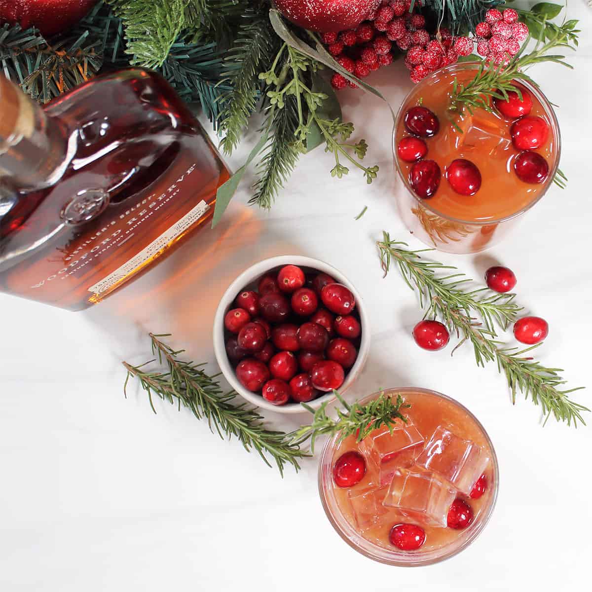 Overhead of two cocktail with garnishes.
