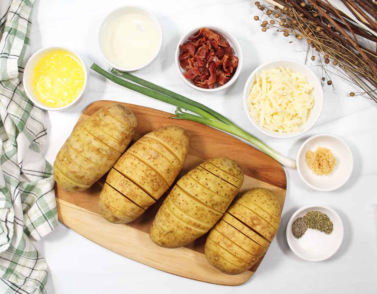 Sliced potatoes on wooden board.