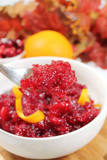 Spoonful of cranberry sauce with Grand Marnier over bowl.