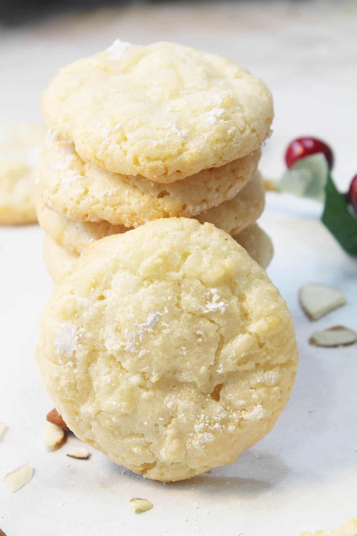 Stacked Almond Cloud Cookies with one leaning on stack.