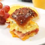 Hawaiian roll slider on plate with fruit.