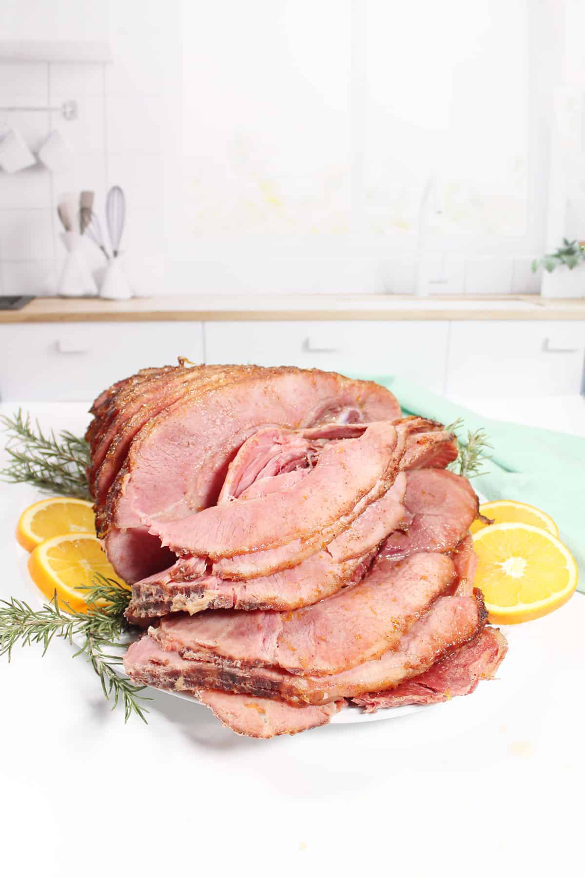 Maple Brown Sugar Glazed Ham on serving plate by window.