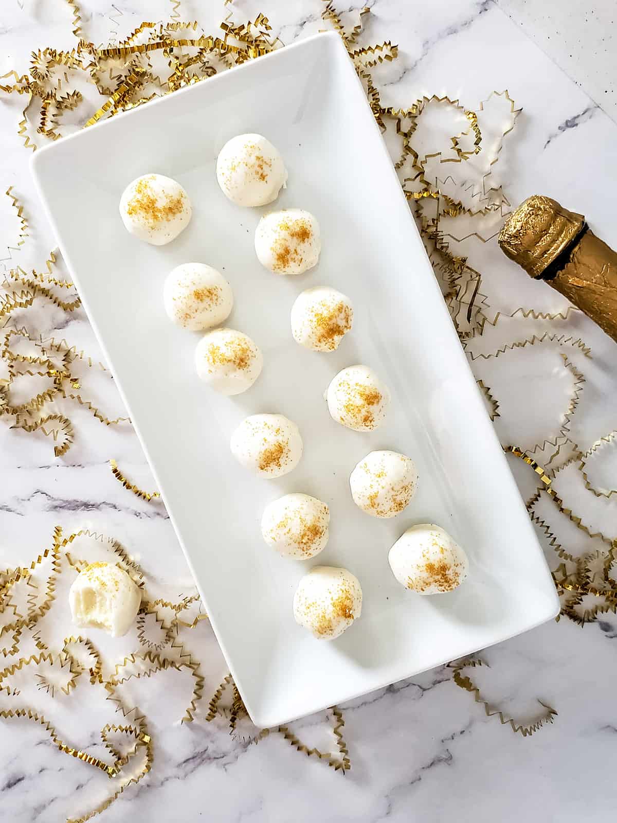 Overhead of platter of truffles with gold sprinkles.
