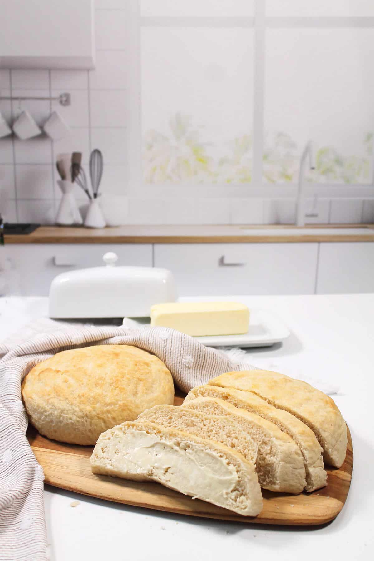 Whole loaf of air fryer bread and sliced bread on wooden board.