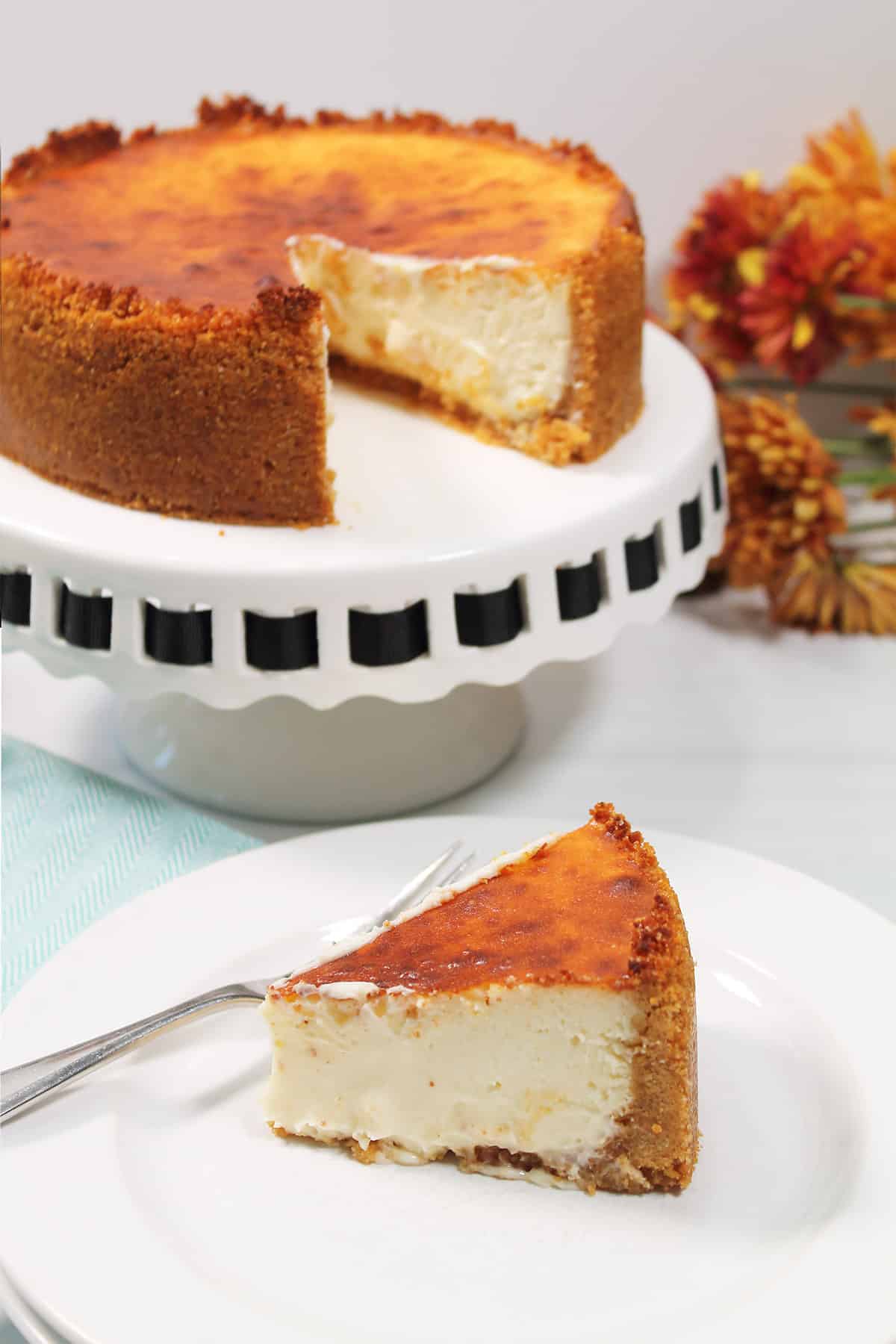 Air Fryer Basque Burnt Cheesecake on pedestal with slice in front.