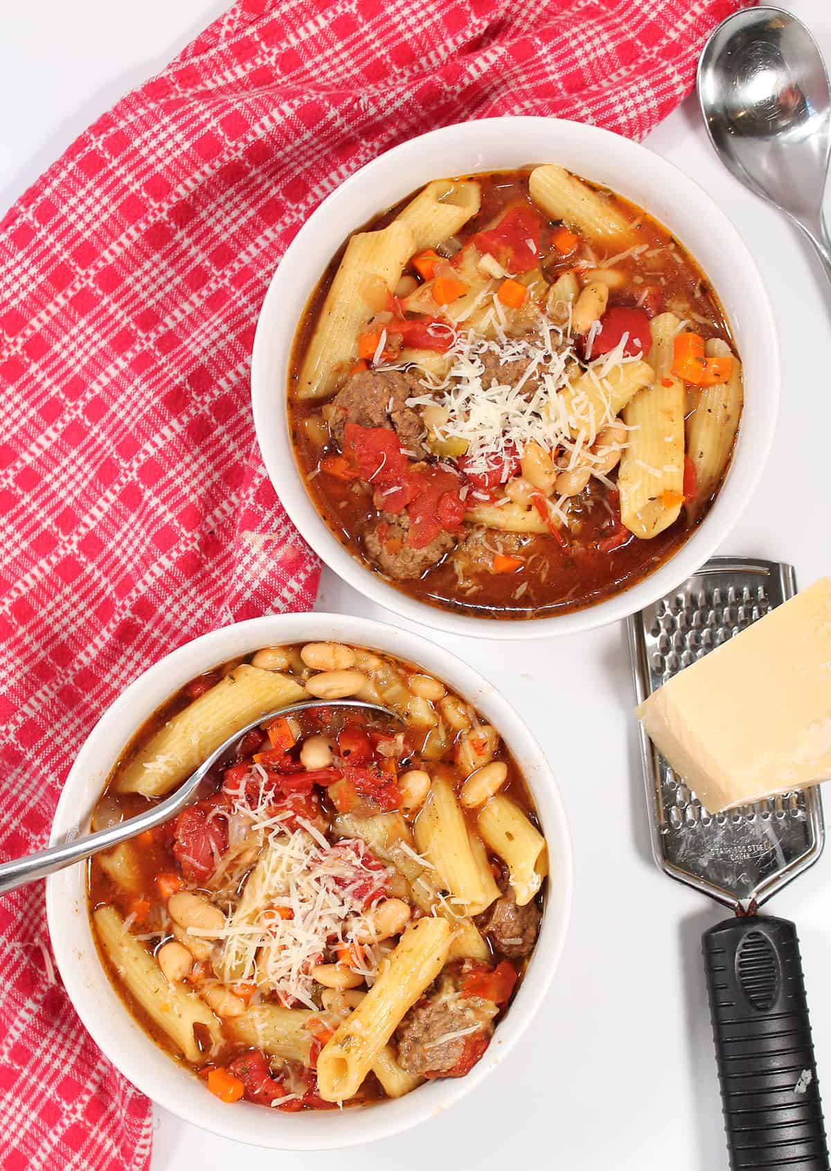 Overhead of hamburger soup with red checkered towel.