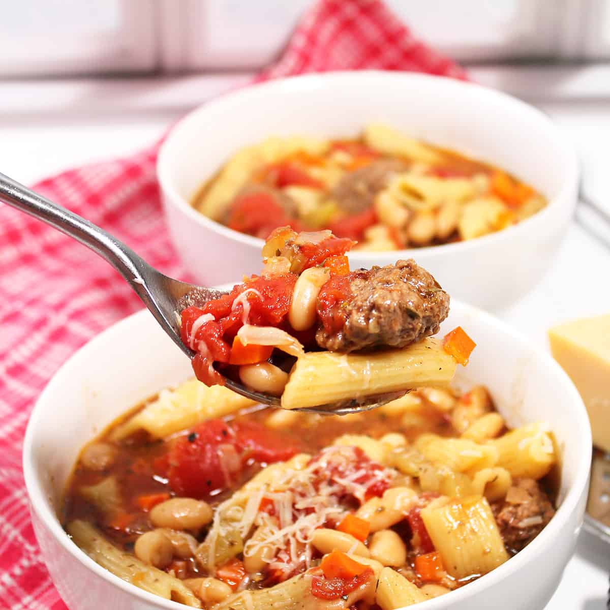 Spoonful of soup over bowl.