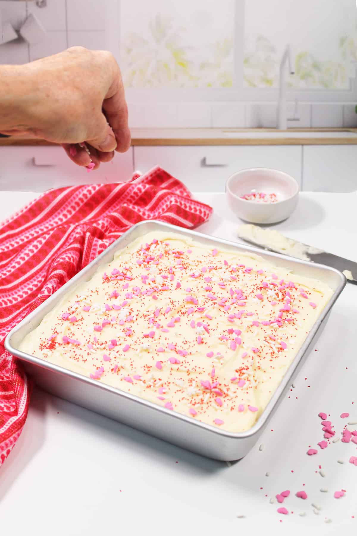 Sprinkling sprinkles on finished brownies.