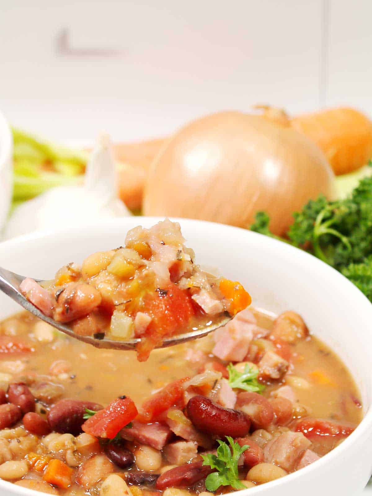 Spoonful of soup over bowl.