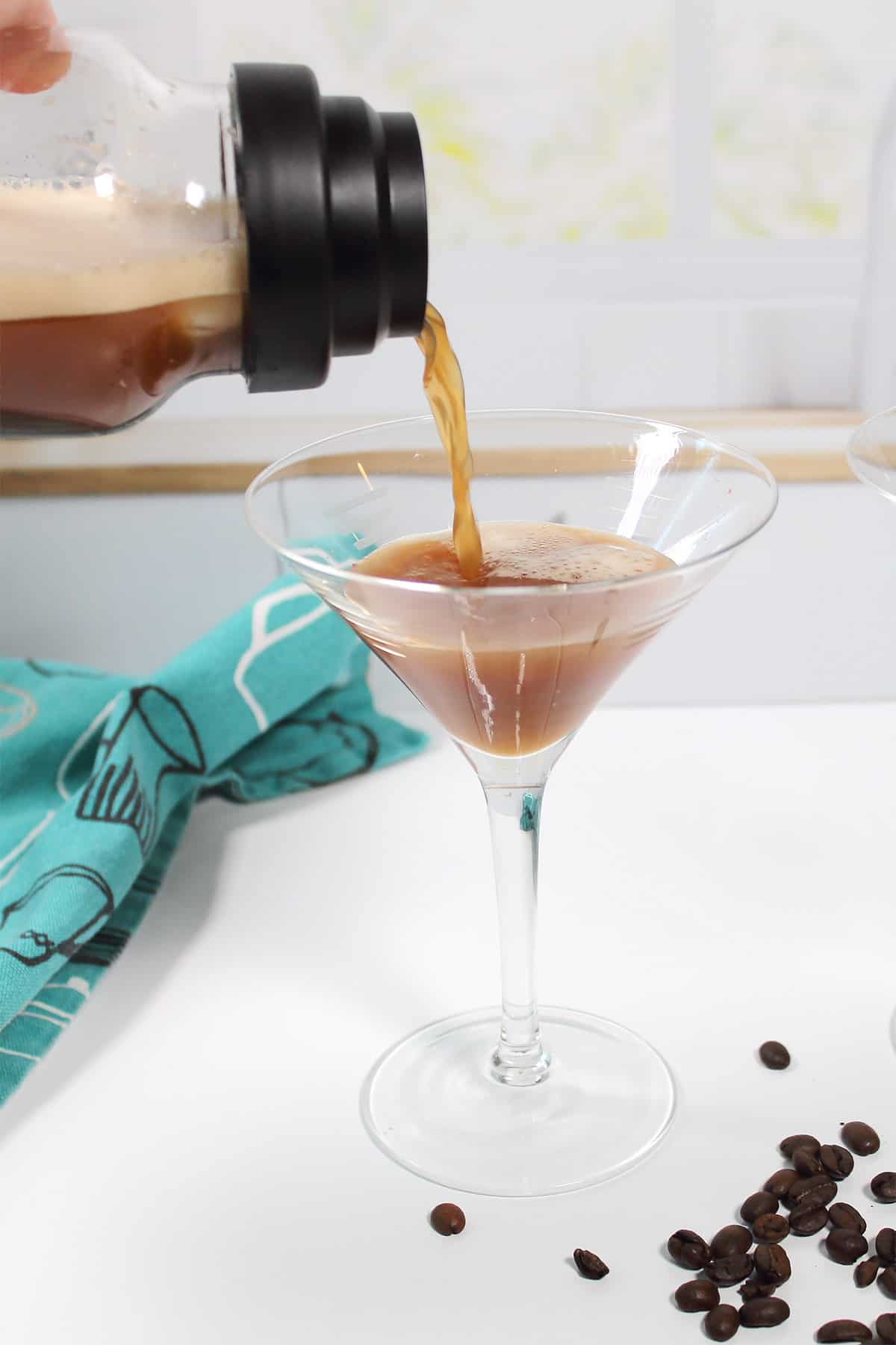 Pouring cocktail into martini glass.