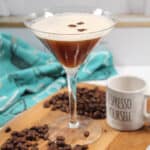 Single cocktail on wooden board with espresso cup.