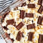 Finished treats in baking dish with chocolate bar on top.